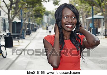 Stock Photography - African American woman standing on city street. Fotosearch