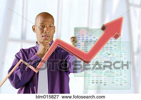 Stock Photo - Black businessman looking at line graph. Fotosearch