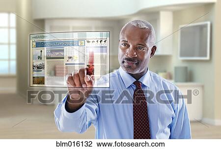 Stock Image - Black businessman using digital display in office. Fotosearch