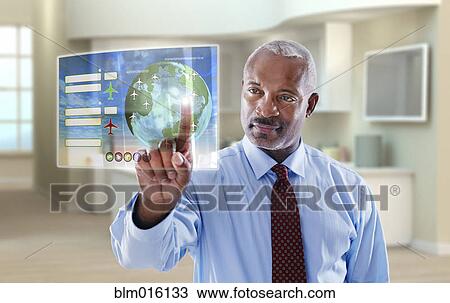 Stock Image - Black businessman using digital display in office. Fotosearch