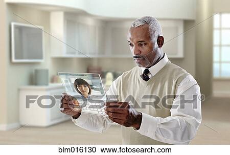 Stock Image - Black businessman using digital tablet in office. Fotosearch