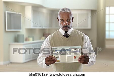 Black businessman using digital tablet in office View Large Photo Image Stock Photo - Black businessman using digital tablet in office. Fotosearch