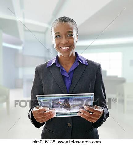 Black businesswoman using digital tablet in office View Large Photo Image Stock Photo - Black businesswoman using digital tablet in office. Fotosearch