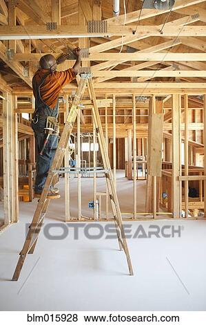 Black carpenter working on ceiling of unfinished room View Large Photo Image Stock Photo - Black carpenter working on ceiling of unfinished room. Fotosearch