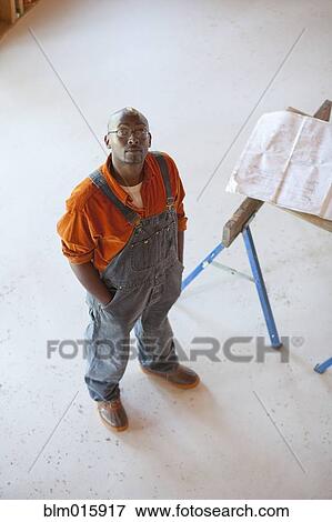 Stock Photo - Black construction worker standing in unfinished room. Fotosearch