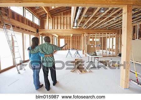 Stock Photo - Black couple standing in unfinished room. Fotosearch