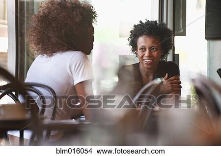 Picture - Black friends sitting together in cafe. Fotosearch
