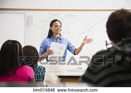 Stock Photo - Black teacher talking to students in class room. Fotosearch