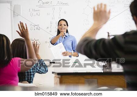 Stock Photo - Black teacher talking to students in class room. Fotosearch
