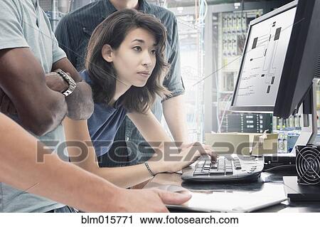 Stock Image - Business people working in server room. Fotosearch
