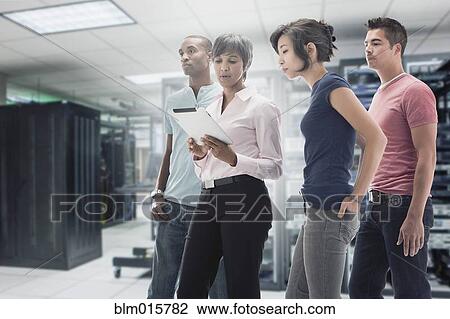Stock Image - Business people working in server room. Fotosearch