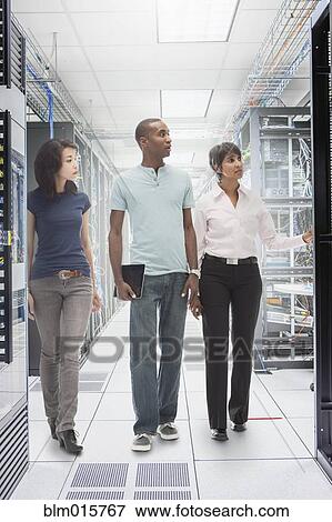 Stock Photo - Business people working in server room. Fotosearch