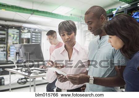 Stock Photograph - Business people working in server room. Fotosearch