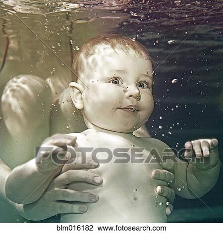 Stock Image - Caucasian baby being held underwater. Fotosearch