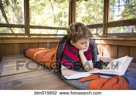 Caucasian boy reading in sleeping bag View Large Photo Image Stock Image - Caucasian boy reading in sleeping bag. Fotosearch