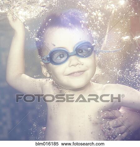 Stock Photography - Caucasian boy swimming under water. Fotosearch