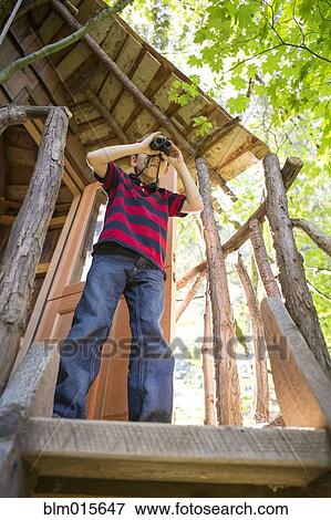 Caucasian boy using binoculars in tree house View Large Photo Image Stock Photo - Caucasian boy using binoculars in tree house. Fotosearch