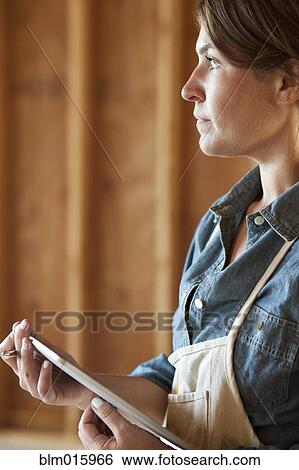 Caucasian construction worker holding digital tablet in unfinished room View Large Photo Image Stock Photograph - Caucasian construction worker holding digital tablet in unfinished room. Fotosearch