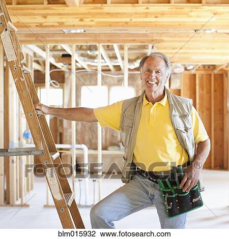 Caucasian construction worker standing in unfinished room View Large Photo Image Stock Image - Caucasian construction worker standing in unfinished room. Fotosearch