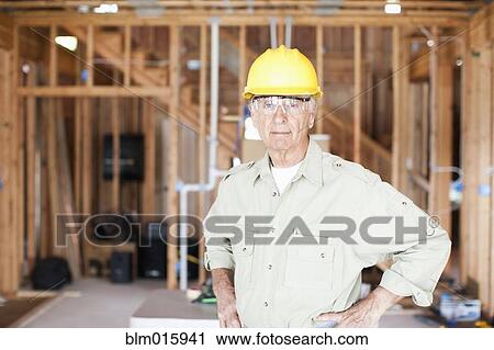 Caucasian construction worker standing in unfinished room View Large Photo Image Stock Image - Caucasian construction worker standing in unfinished room. Fotosearch