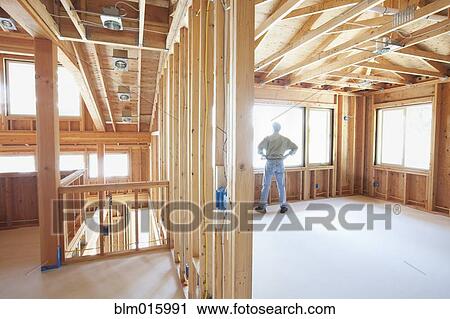 Caucasian construction worker standing in unfinished room View Large Photo Image Stock Image - Caucasian construction worker standing in unfinished room. Fotosearch