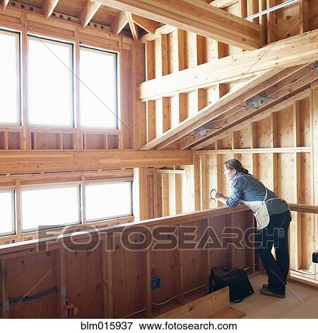 Stock Photo - Caucasian construction worker standing in unfinished room. Fotosearch