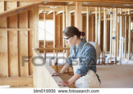 Stock Photography - Caucasian construction worker standing in unfinished room. Fotosearch