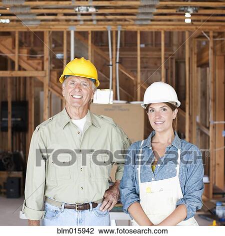 Caucasian construction workers standing in unfinished room View Large Photo Image Stock Image - Caucasian construction workers standing in unfinished room. Fotosearch