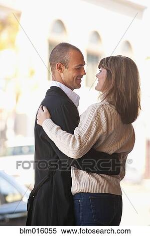 Stock Photography - Caucasian couple hugging outdoors. Fotosearch