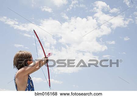 Stock Photo - Caucasian girl aiming bow and arrow. Fotosearch