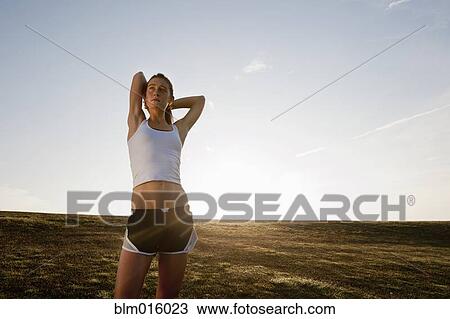 Stock Image - Caucasian runner stretching before exercise. Fotosearch