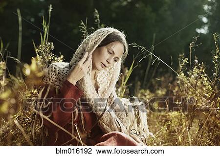 Caucasian woman in scarf sitting in field View Large Photo Image Stock Image - Caucasian woman in scarf sitting in field. Fotosearch