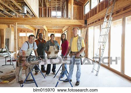 Stock Image - Construction workers in unfinished room. Fotosearch
