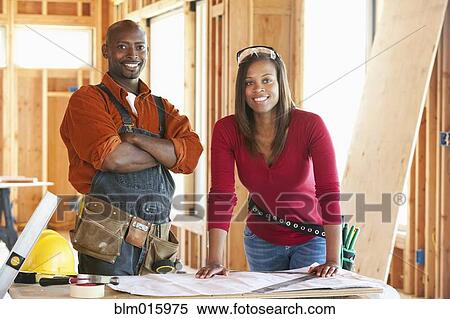Stock Photography - Construction workers in unfinished room. Fotosearch