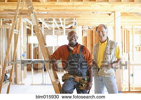 Construction workers standing in unfinished room View Large Photo Image Stock Image - Construction workers standing in unfinished room. Fotosearch