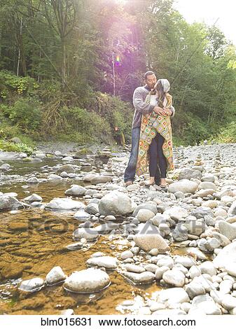 Stock Image - Couple hugging near stream. Fotosearch