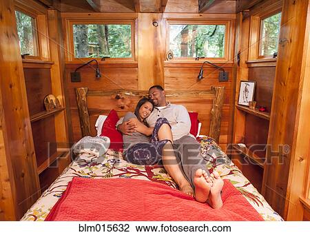 Stock Image - Couple laying together in bed. Fotosearch