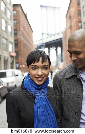 Stock Photo - Couple standing together on city street. Fotosearch