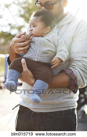 Stock Photo - Father holding African American baby boy. Fotosearch