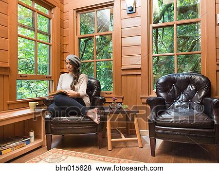 Stock Photo - Filipino woman reading in chair. Fotosearch