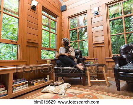 Stock Photo - Filipino woman reading in chair. Fotosearch