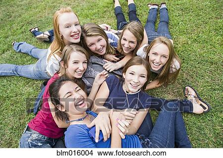 Picture - Friends hanging out together on grass. Fotosearch