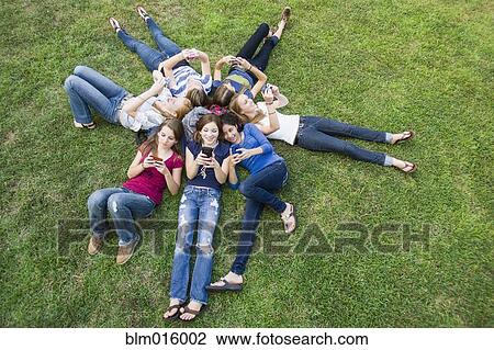 Friends hanging out together on grass View Large Photo Image Stock Image - Friends hanging out together on grass. Fotosearch