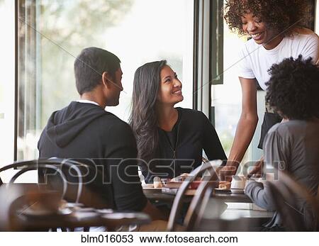 Friends sitting together in cafe View Large Photo Image Stock Image - Friends sitting together in cafe. Fotosearch