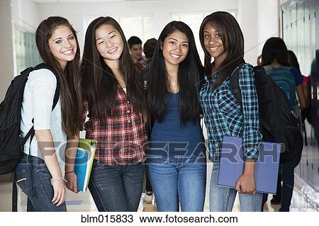 Stock Image - High school friends standing in corridor together. Fotosearch