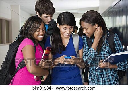 Stock Photo - High school students looking at cell phone together. Fotosearch