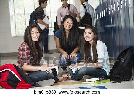 Stock Photo - High school students sitting in corridor together. Fotosearch