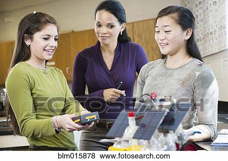High school teacher talking to student about solar powered machine View Large Photo Image Stock Photo - High school teacher talking to student about solar powered machine. Fotosearch