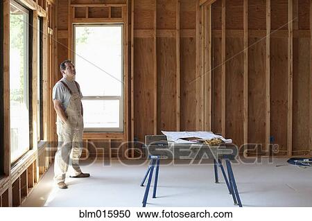 Hispanic construction worker standing in unfinished room View Large Photo Image Stock Image - Hispanic construction worker standing in unfinished room. Fotosearch