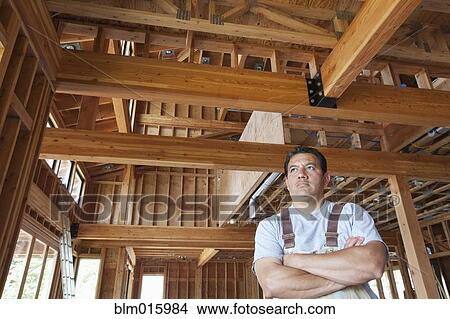 Hispanic construction worker with arms crossed in unfinished room View Large Photo Image Picture - Hispanic construction worker with arms crossed in unfinished room. Fotosearch